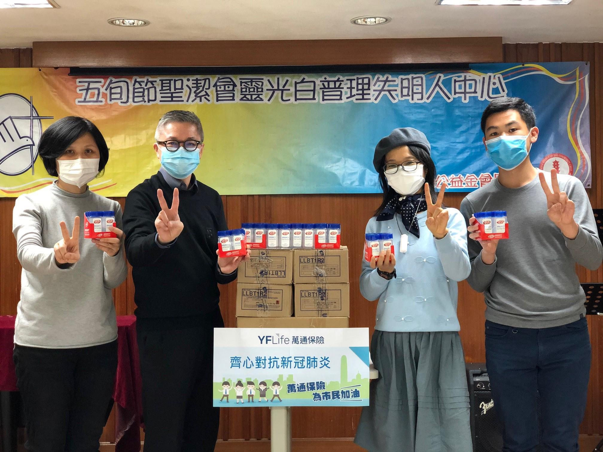 萬通保險市務部副總裁葉偉傑先生（左二）代表公司向香港公益金會員機構五旬節聖潔會靈光白普理失明人中心送上消毒搓手液。